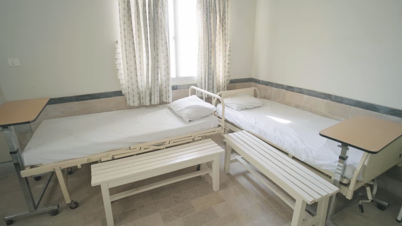 Empty hospital beds in a ward of hospital with sulight entering in Pakistan.
