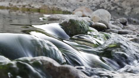 close-up shot of water flowing between rocks in natural pools of a river