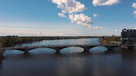 Vista-Aérea-Del-Puente-Sobre-El-Río,-Infraestructura-Suburbana,-Autos-Pasando,-Tráfico,-Carretera,-Calle,-Vista-De-Drones,-Ciudad,-Transporte,-Escena,-Panorama,-Horizonte,-Paisaje-Urbano