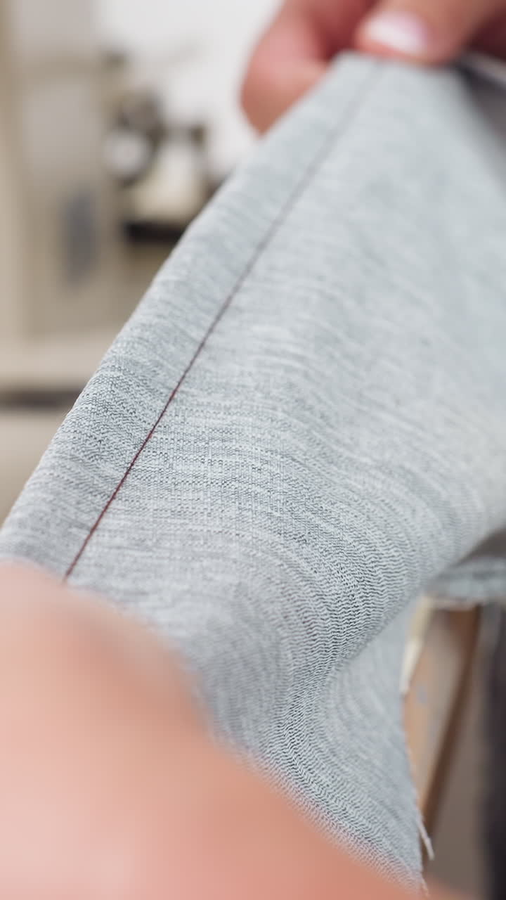 Seamstress preparing fabric with pins, Closeup of hands working with fabric edges, Focused seamstress delicately aligning fabric seam using pins and pen in peaceful studio environment