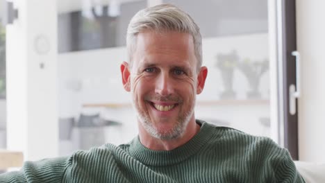 Video-portrait-of-senior-caucasian-man-smiling-and-laughing-to-camera-indoors