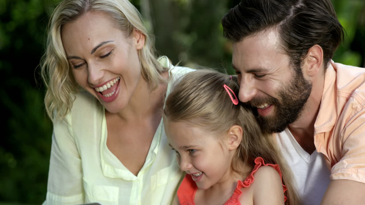 Ritratto di famiglia carina che guarda un laptop e sorride