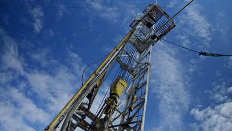 oil rig working outdoors. low angle view on the metal tower with drilling equipment.