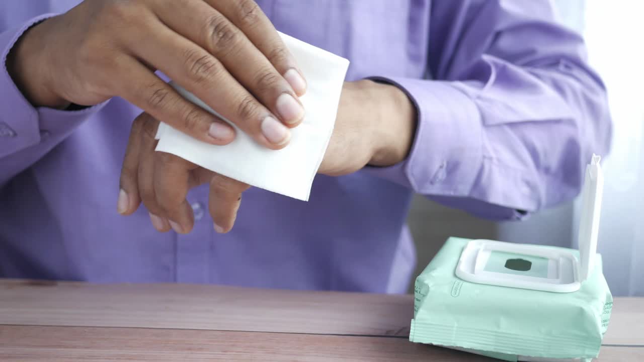 persona que se limpia las manos con toallitas húmedas