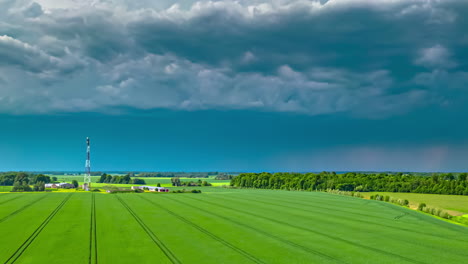 Disparo-Aéreo-De-Hiperlapso-De-Drones-De-Una-Nube-De-Lluvia-Moviéndose-Sobre-Tierras-De-Cultivo-Verdes-A-Lo-Largo-Del-Campo-Rural-En-Un-Día-Nublado