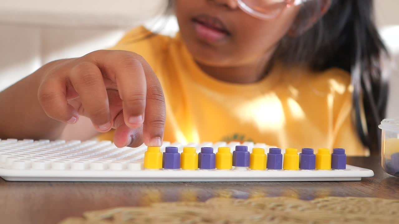 una niña jugando con una tabla de clavos