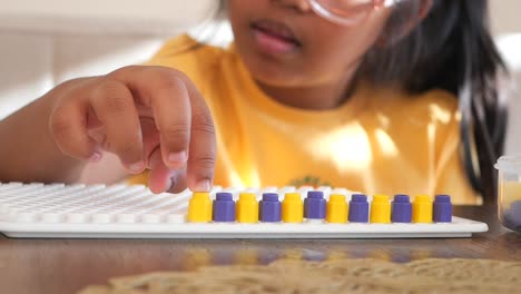 little girl playing with peg board