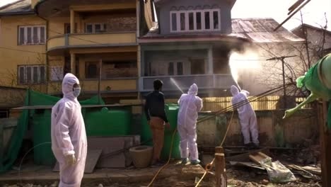 white kit wearing frontline men warriors are in a single line and ready to fight against coronavirus  and sanitize srinagar india.