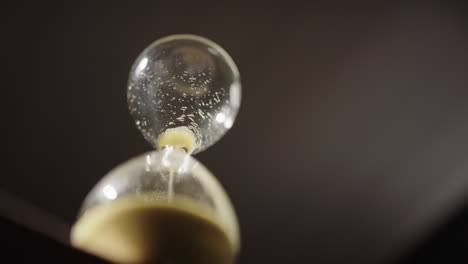 last sand particles falling through bottleneck of hourglass, deadline concept