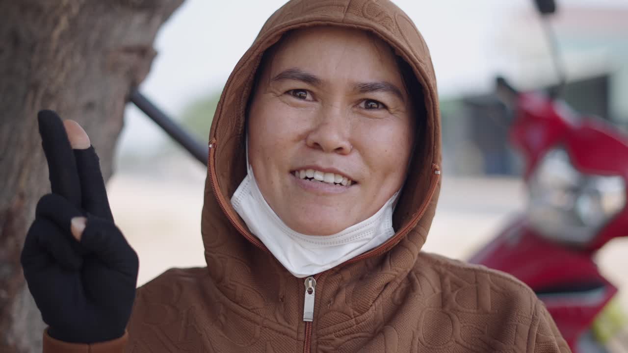 Woman wearing a hoodie and mask outdoors