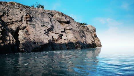 Tropical-rock-island-against-blue-sky-and-sea