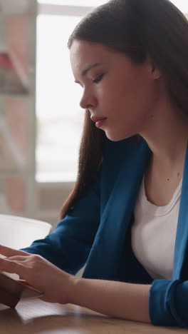 woman flips through pages of old book in library. lady reads vintage novel at desk in college engaged in literature work for essay. studying woman closeup