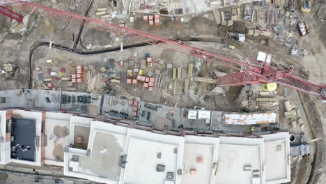 overhead view of a construction site with cranes and building material