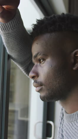 video of sad african american man looking outside window