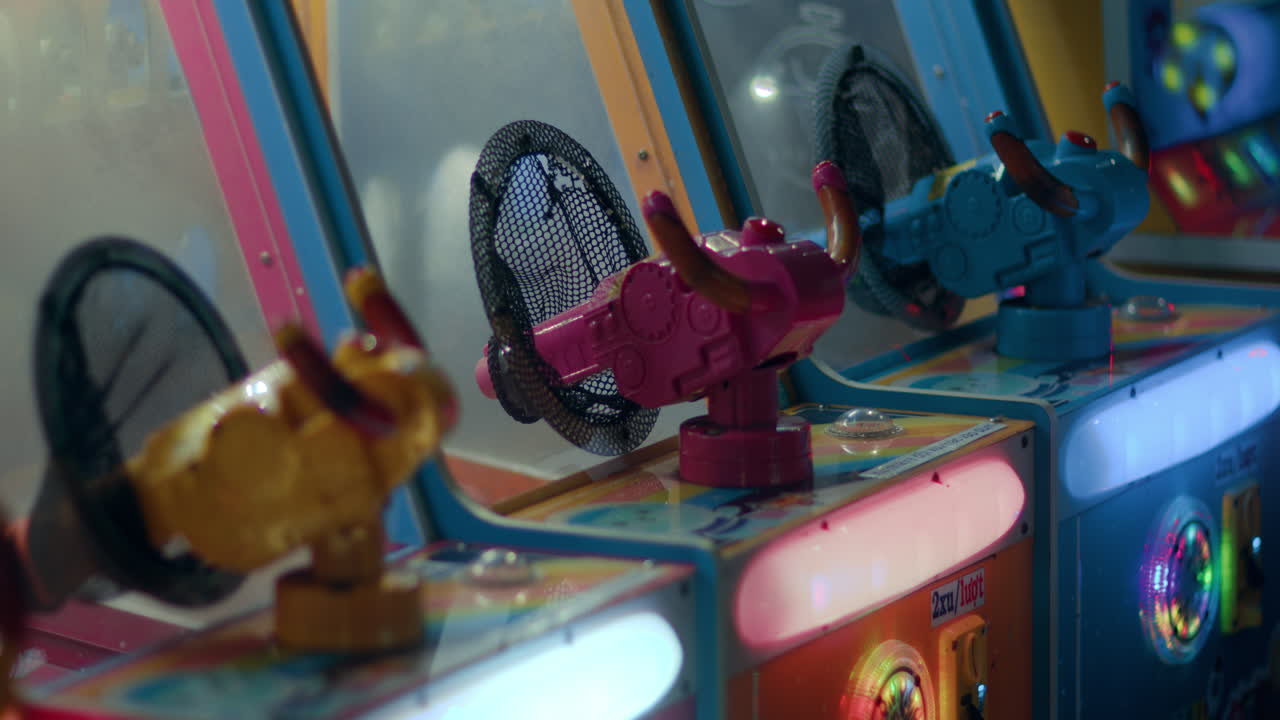 Luces intermitentes y brillantes de juegos de feria con pistolas de agua de plástico de colores.