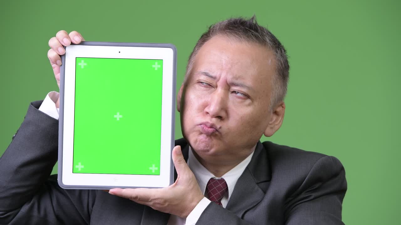 디지털 태블릿을 보여주는 성숙한 일본 사업가