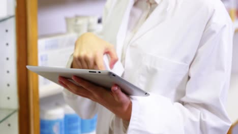 farmacéutico usando una tableta digital mientras revisa medicamentos