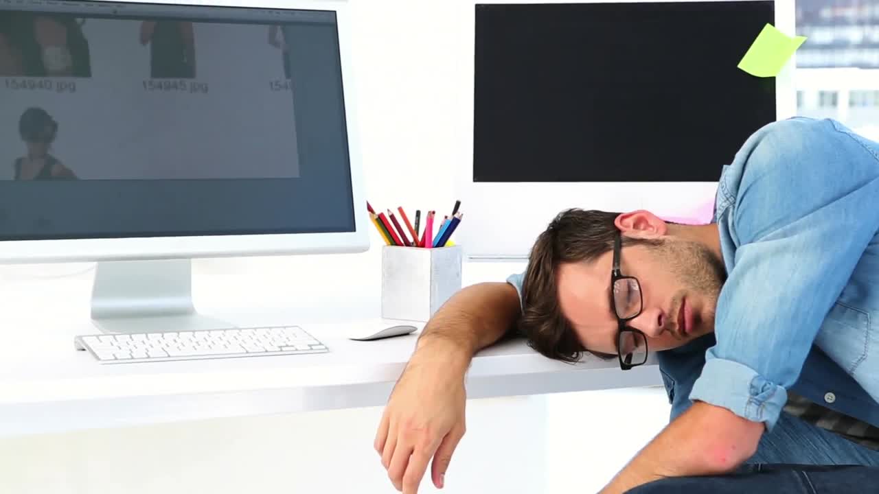 Photo editor sleeping at his desk