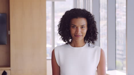 portrait of businesswoman in office walking towards camera