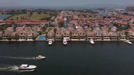 Yachts-sailing-through-a-water-channel-in-the-city-of-Lechería,-northern-Anzoátegui-state,-Venezuela