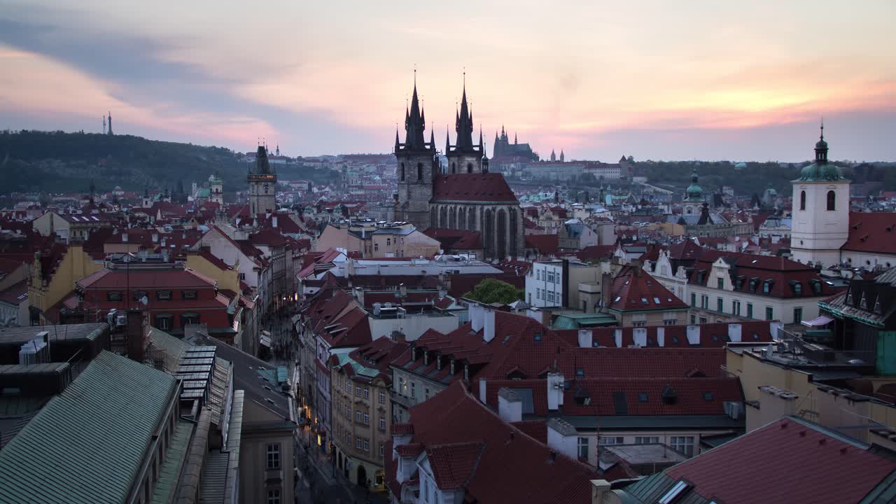 Time-lapse do pôr do sol do dia para a noite da Torre da Pólvora, Antiga Câmara Municipal, Castelo de Praga e o restante do centro de Praga, República Tcheca, enquanto se ilumina durante a noite.