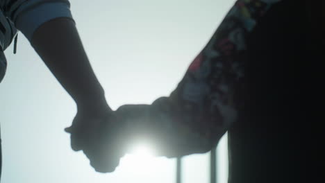mother and daughter holding hands outdoors