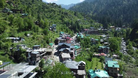 aerial view short of jibhi himachal pradesh in india. houses and trees in the mountainous area. faguli festival is one of the biggest festival in jibhi. the traditional houses here have stone roofs.