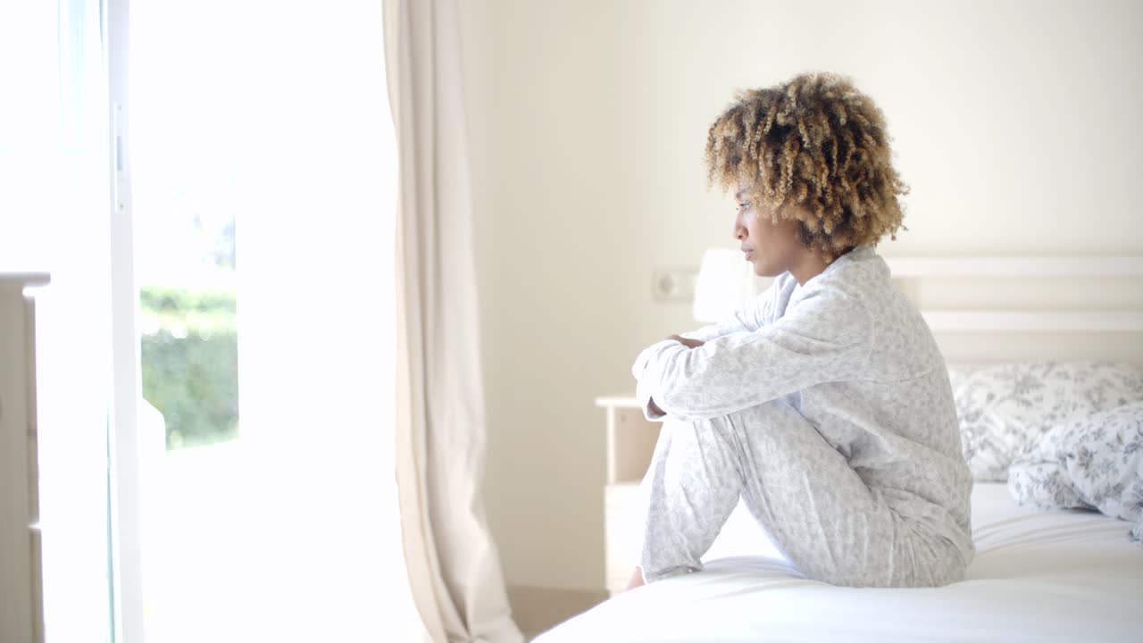 Donna triste seduta sul letto