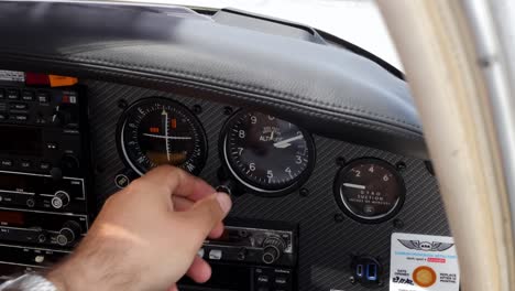 A-man's-hand-adjusting-the-instrument-panel-of-a-light-aircraft