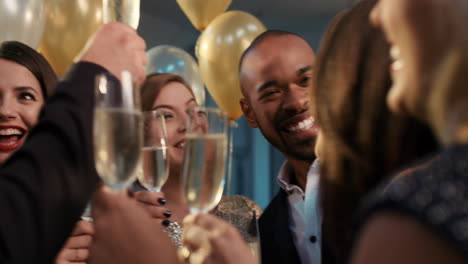 friends holding up champagne flutes together in a toast at party