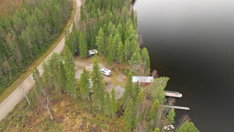 sweden - a stunning view with colorful autumn trees, a charming lake, and a campervan nearby on a cloudy day in october - aerial drone wide shot