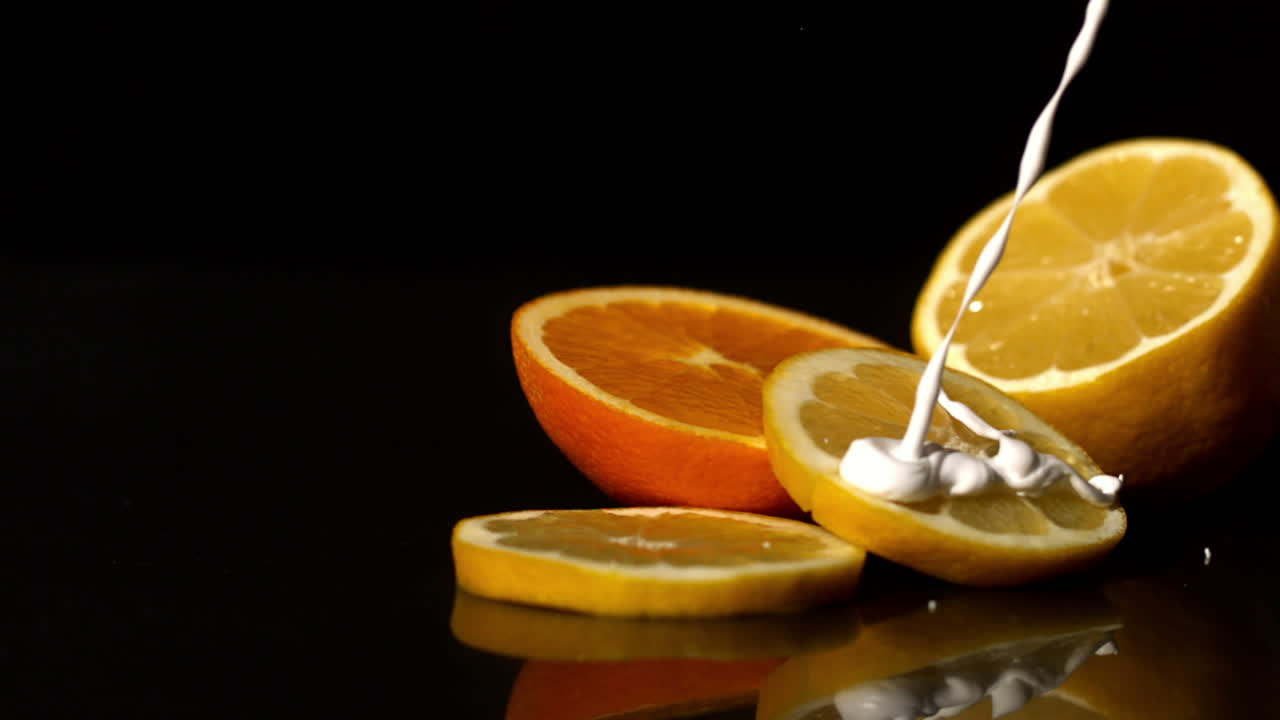 Schlagsahne fließt auf Orangenscheiben