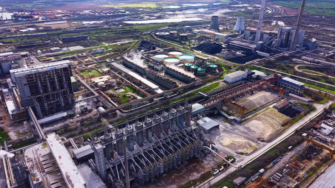Industrial area with multiple buildings, machinery, and processing plants during daylight in a city landscape