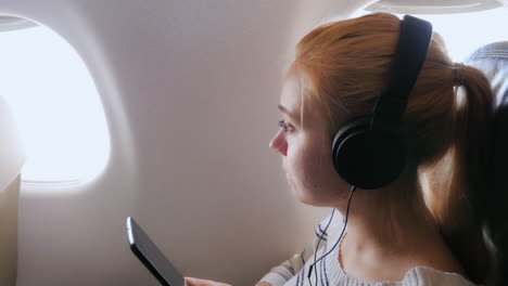 young attractive woman is flying in an airplane 3