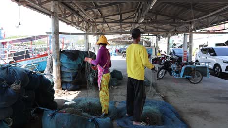 two people working together at a fishing dock