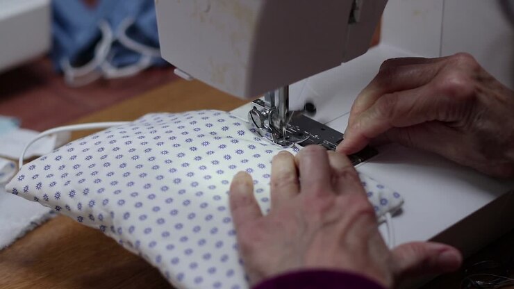 A Seamstress Sewing Cloth Facemasks At Home With Sewing Machine During COVID-19 Outbreak - Closeup Shot