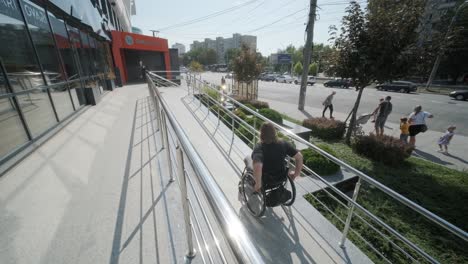 a woman in a wheelchair ascends a ramp next to a staircase in an urban environment, highlighting accessible infrastructure and inclusive design. the image emphasizes mobility, independence, and modern city planning.