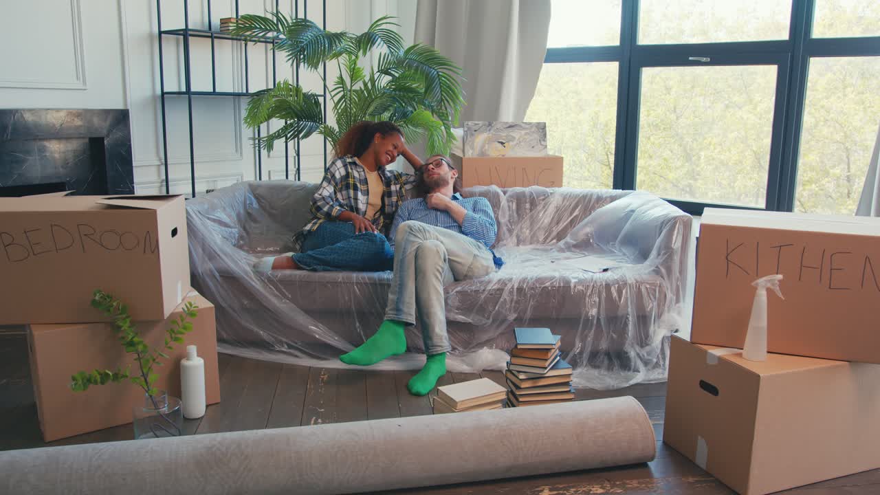 joven pareja feliz diversa de hombre mujer descansando después de mudarse