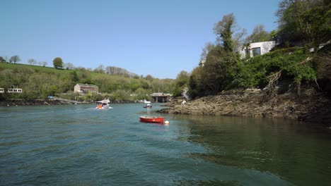 crossing the river fowey with views down the estuary of bobbing boats and luxury houses on a hot bright day