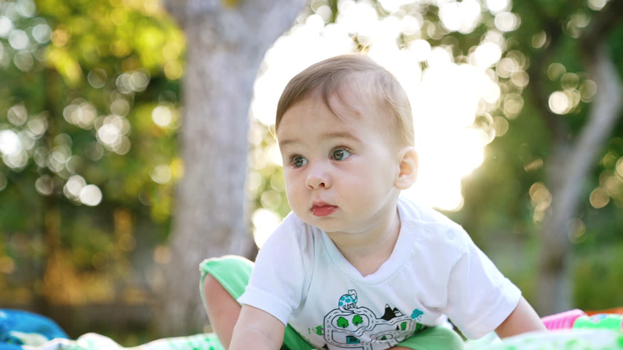 Beautiful little boy in summer clothes outdoors. Adorable toddler exploring the place outside. Close up. Low angle view.