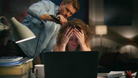 hombre secando riendo mujer en el lugar de trabajo remoto primer plano. mujer tratando de ignorar a su cónyuge