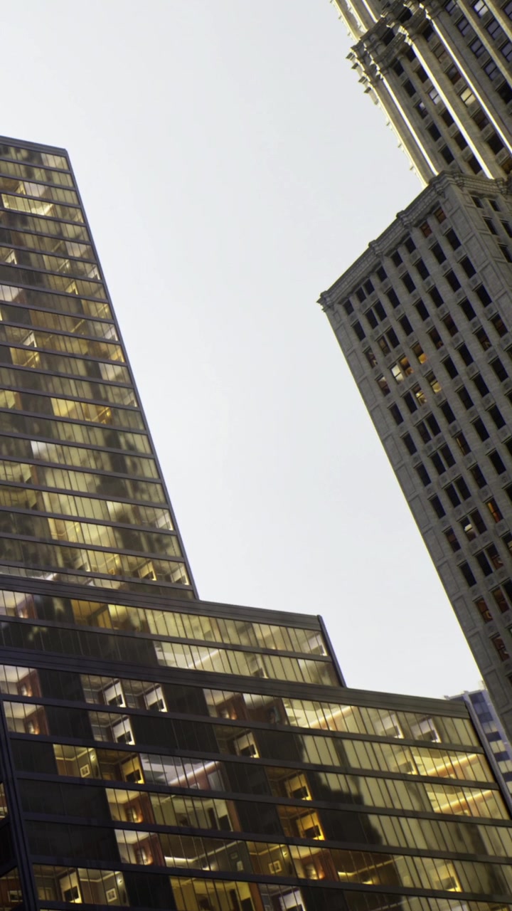 Edifícios urbanos refletem a luz do sol em um ambiente urbano movimentado.
