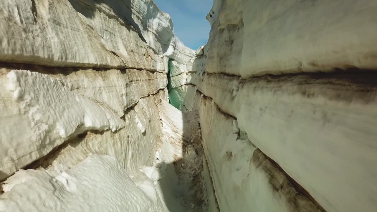 Veduta aerea attraverso un canyon di ghiaccio, crepato sulla superficie ghiacciata di un ghiacciaio islandese, in una giornata di sole