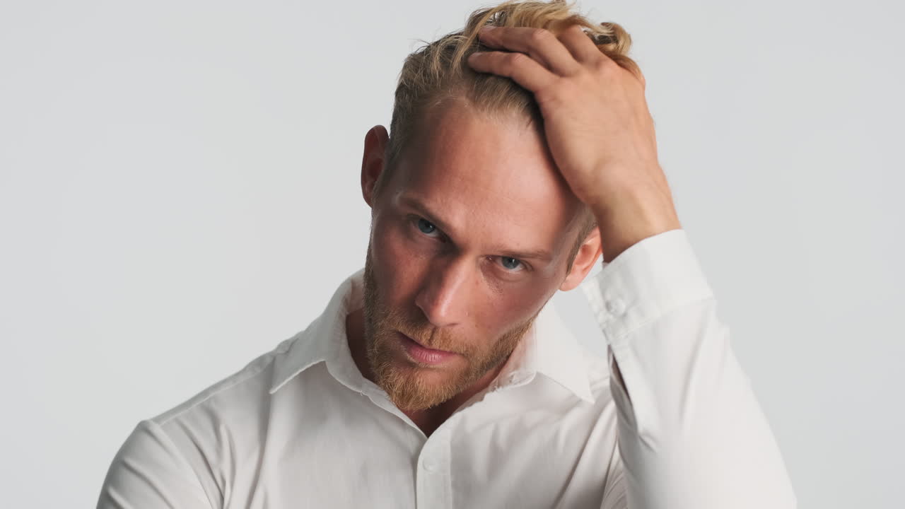 심각한 수염이 있는 남자가 포즈를 취하고 있습니다.