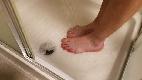 person washing feet in a shower