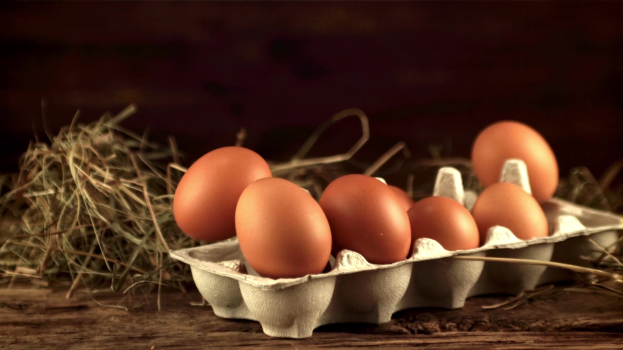 Carton of fresh brown eggs appearing on a rustic wooden table