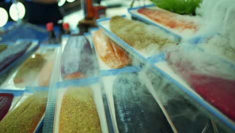 open buffet of processed salmon fish. Slow motion footage of the cold steam coming over them.