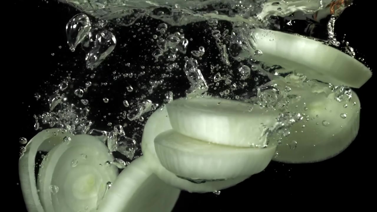Sliced White Onions Falling into Water in Slow Motion