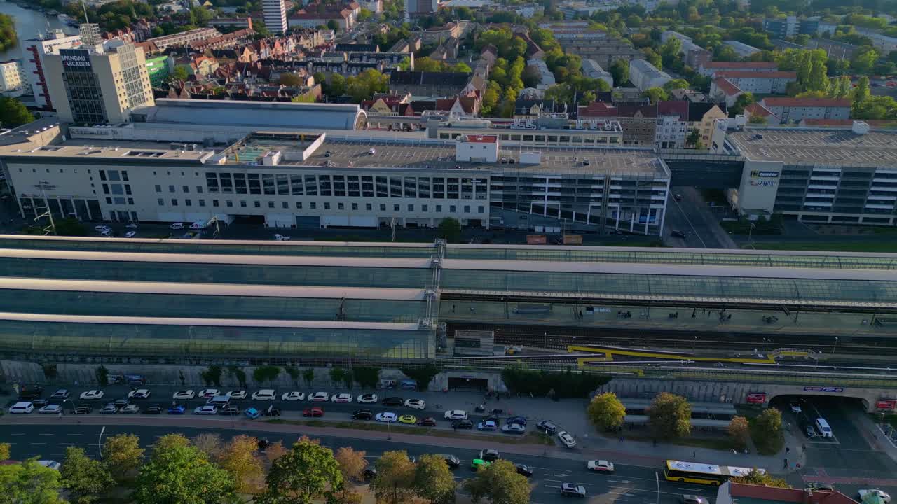 Berlin Spandau train station and Mall shopping center with surrounding urban landscape. Tremendous aerial view flight drone camera pointing down