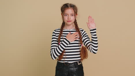 child girl raising hand to take oath promising to be honest and to tell truth keeping hand on chest
